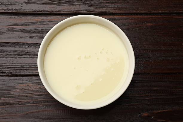 istock Condensed milk in bowl on wooden table, top view 2234842079