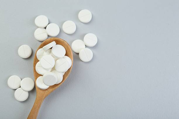 istock Antibiotic pills in wooden spoon on grey background, top view. Space for text 2234843365