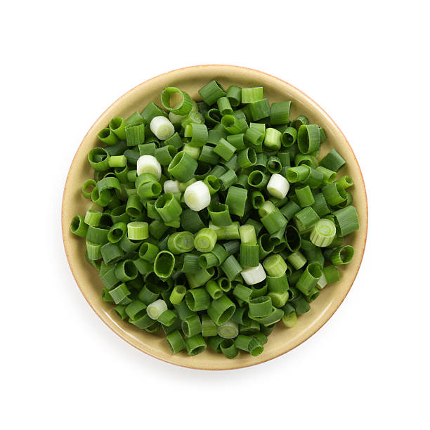 istock Chopped fresh green onion in bowl isolated on white, top view 2234843773