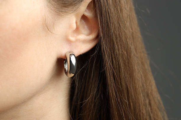 istock Woman wearing beautiful silver earring on grey background, closeup 2234845701