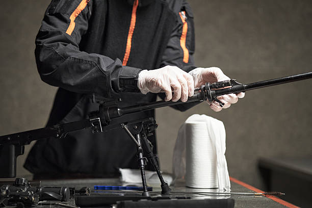 istock Young Adult Man Assembling Rifle While Wearing Protective Gloves 2234845776
