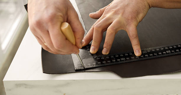 istock Craftsman hands marking natural leather with awl and ruler 2234847979