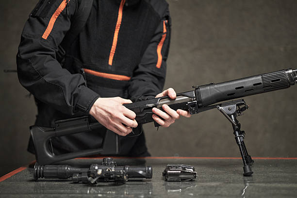 istock Young Adult Man Assembling Assault Rifle Indoors during Training 2234848754