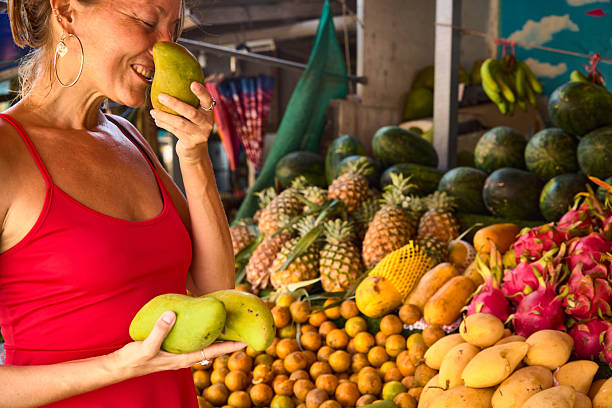 Woman selecting fresh tropical fruits at a local market