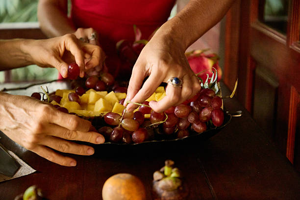 istock People sharing fresh fruits on a wooden table creating a cozy dining atmosphere 2234849933