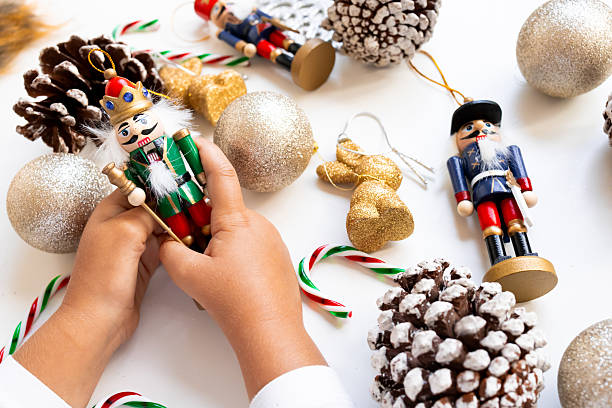 istock Child hands holding nutcracker among festive Christmas ornaments and pinecones 2234850095