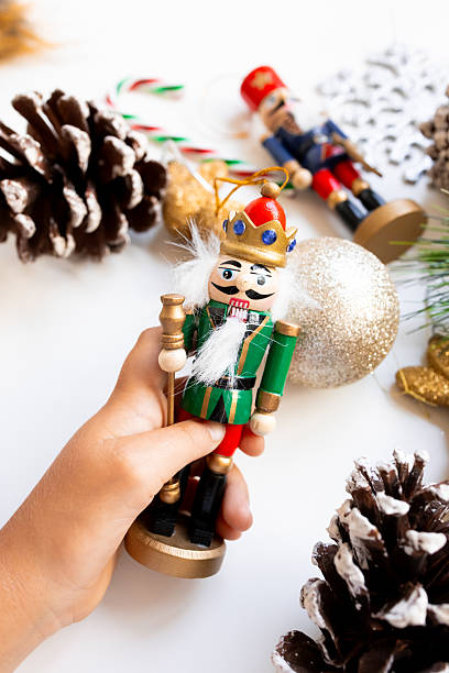 istock Festive Christmas nutcracker in hand with decorations and pinecones 2234850099