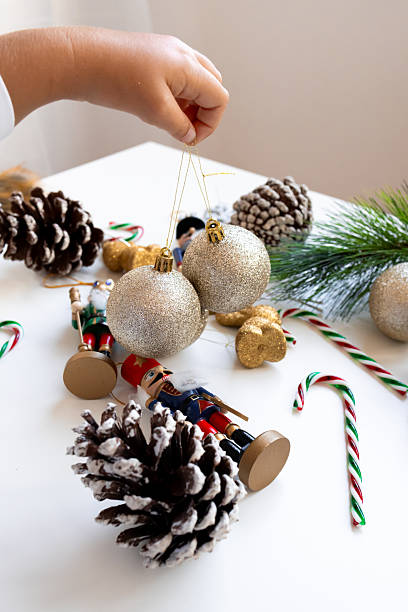 istock Festive holiday decorations with silver ornaments and pinecones on a white table 2234850107