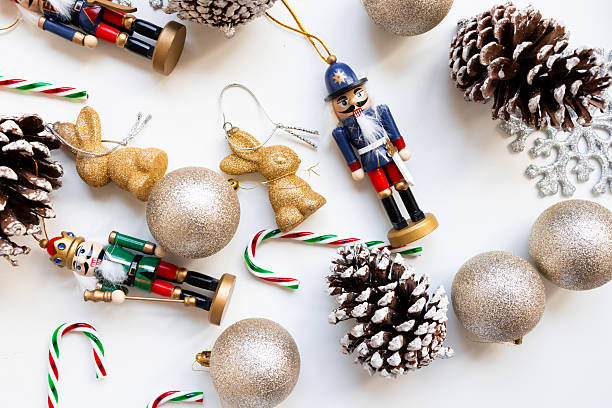 istock Festive nutcracker and christmas ornaments with pine cones and candy canes on white background 2234850680