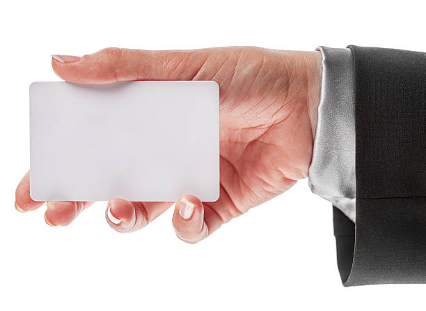 istock Woman's hand in black office suit holds empty white plastic card isolated on white background. 2234851104