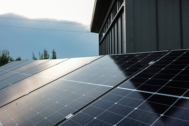 istock Solar panel installations beside a modern utility building in a green field, generating renewable energy on a sunny day 2234855376