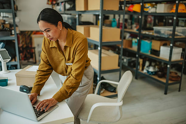istock Asian woman manages warehouse operations while organizing deliveries and assisting with orders 2234855572