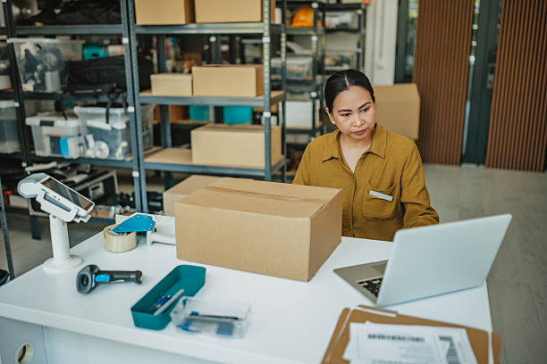 istock Asian woman manages warehouse operations while packing orders at a distribution center 2234855620