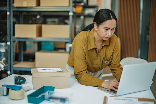 istock Asian woman manages warehouse operations while preparing packages for shipment 2234855638
