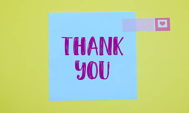 istock Thank you text on white sticky note on yellow background 2234856734