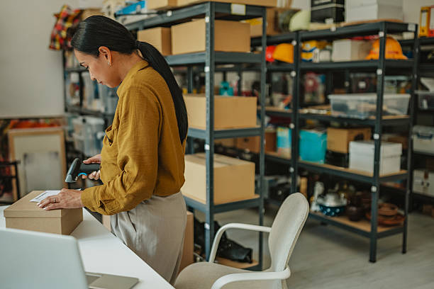 istock Asian woman managing operations in a warehouse while preparing packages for delivery 2234856753