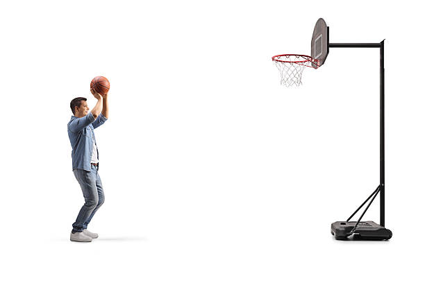 Portrait of teenage athlete with basketballs spinning on fingers against white background.