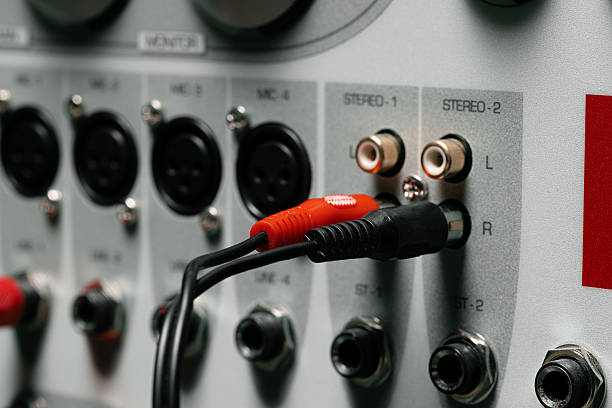 Close-up of a technician's hand holding audio jacks while working on a server rack