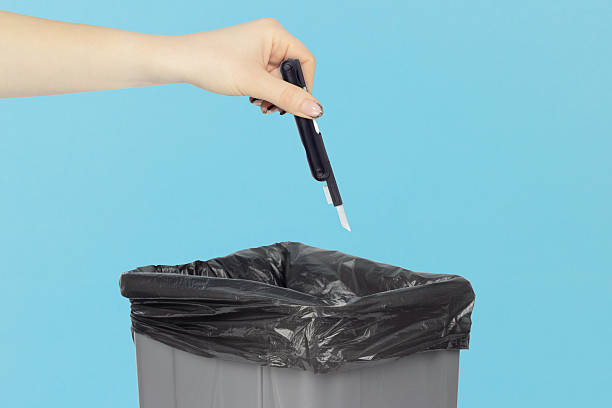 istock throwing multitool for cleaning headphones into trash, outstretched hand with multitool for cleaning headphones in front of trash can 2234859440