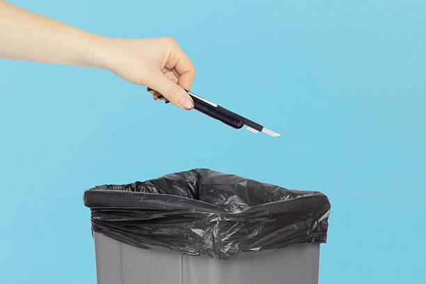 istock throwing multitool for cleaning headphones into trash, outstretched hand with multitool for cleaning headphones in front of trash can 2234859441