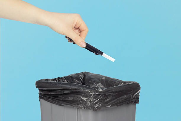 istock throwing multitool for cleaning headphones into trash, outstretched hand with multitool for cleaning headphones in front of trash can 2234859452