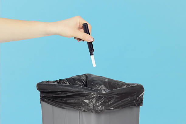 istock throwing multitool for cleaning headphones into trash, outstretched hand with multitool for cleaning headphones in front of trash can 2234859453