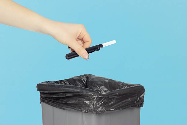 istock throwing multitool for cleaning headphones into trash, outstretched hand with multitool for cleaning headphones in front of trash can 2234859458