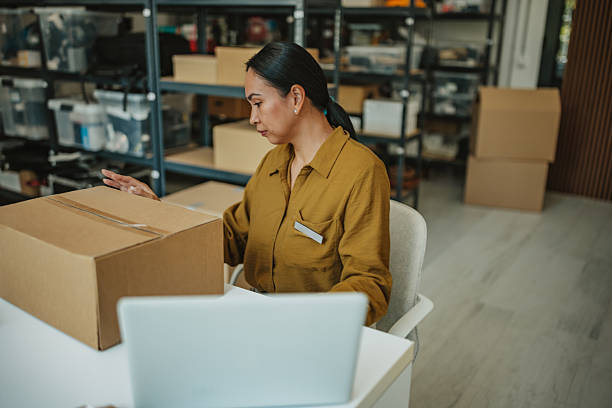 istock Young Asian woman managing orders in a distribution warehouse during daylight hours 2234859491