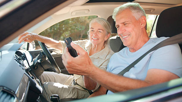 istock Senior Couple In Car Using GPS Sat Nav On Mobile Phone On Day Trip Out 2234860150