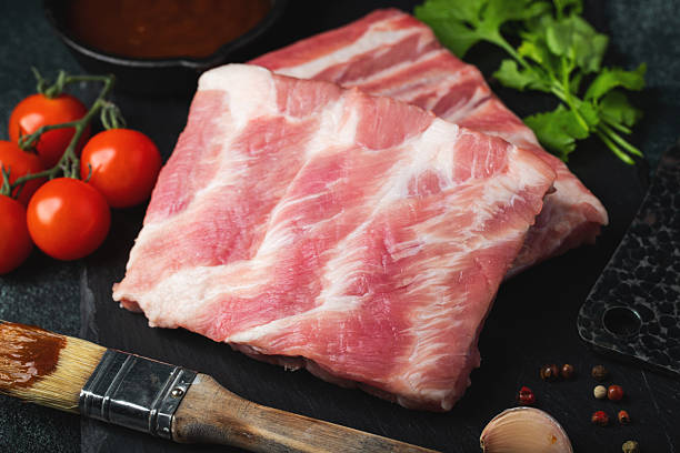 istock Raw meat. Raw pork ribs from the back with meat on a black background. background image 2234860777