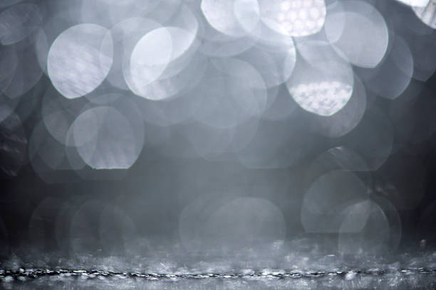 This visually captivating abstract, defocused and soft focus image presents luminous shiny circles that deliver a gently glowing effect enriched by subtle glitter textures. The sophisticated interplay of silver colored and gray color tones conveys refined luxury and understated elegance, making this backdrop a highly versatile design element with extensive copy space. Ideal for use in stylish celebrations, festive party - social events, sophisticated weddings, special anniversaries, and holiday designs such as Christmas, New Year's Eve, and Valentine's Day - Holiday, it's also perfectly suited for decorative projects (web banner, wallpaper - decor), elegant slide show, and creative digital design.