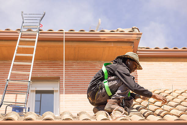 Young african american man working on a roof, installing photovoltaic solar panels