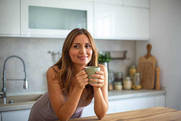 istock Smiling woman enjoying morning coffee in kitchen 2234865300