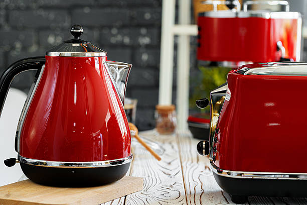 Red kettle on kitchen counter table close up