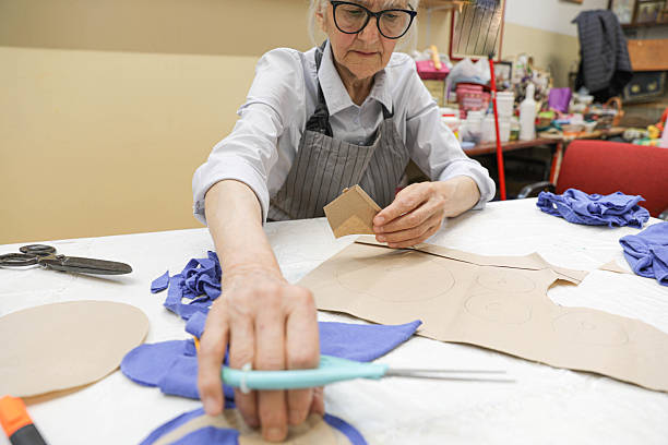 istock Female Tailor Cutting Blue Fabric Using Paper Templates 2234869679