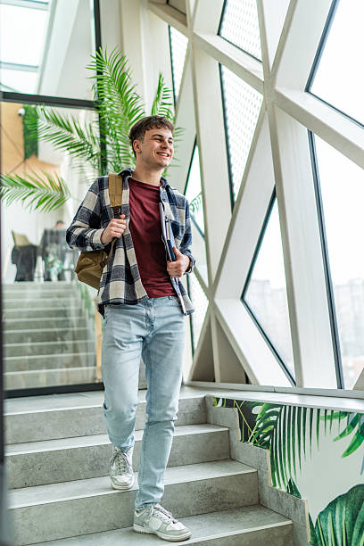 istock Smiling student walking up stairs at university 2234869893