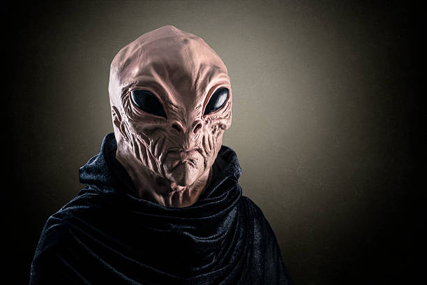 Mysterious humanoid alien at night over dark misty background