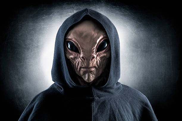 Mysterious humanoid alien at night over dark misty background