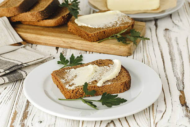 istock Buttered slice of rye bread on wooden table 2234873103