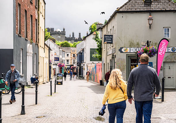 Kilkenny, Ireland - Pedestrians in the city centre, with Kilkenny Castle visible on the skyline.