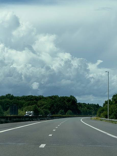 Huge, towering cumulous clouds hang over the E34 motorway in Belgium on a hot summer's day in July