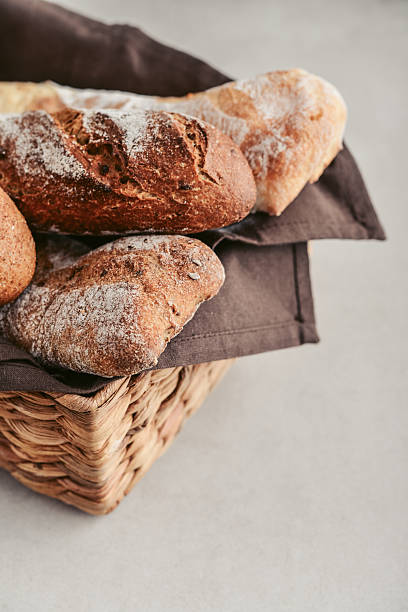 istock Assorted bakery products including loafs of bread,  baguette and rolls in basket 2234876071