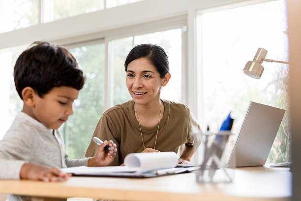 istock Happy mother helping her son with homework using laptop 2234876857