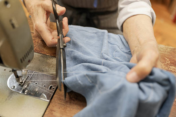istock Senior Woman Trimming Thread On Sewing Machine With Scissors 2234878844