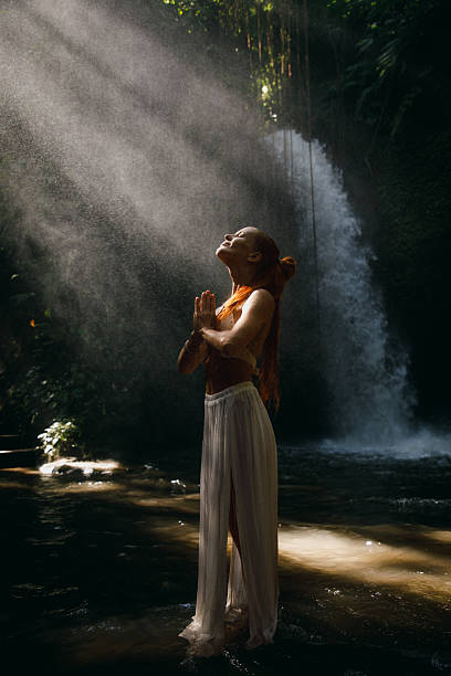 istock Woman practicing mindfulness by a serene waterfall in natural forest landscape 2234884816