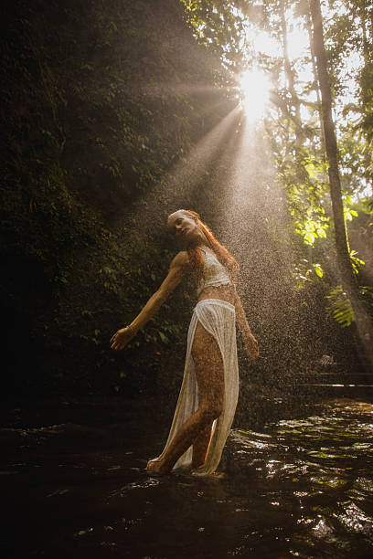 istock Woman enjoying natural water spray in a tranquil forest setting 2234885127