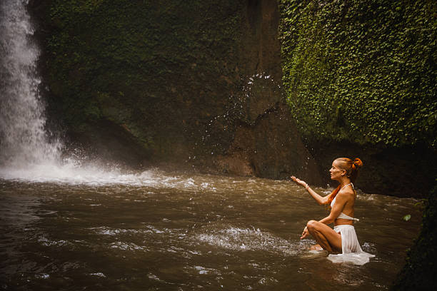 istock Woman enjoying a tranquil waterfall surrounded by lush greenery 2234885134