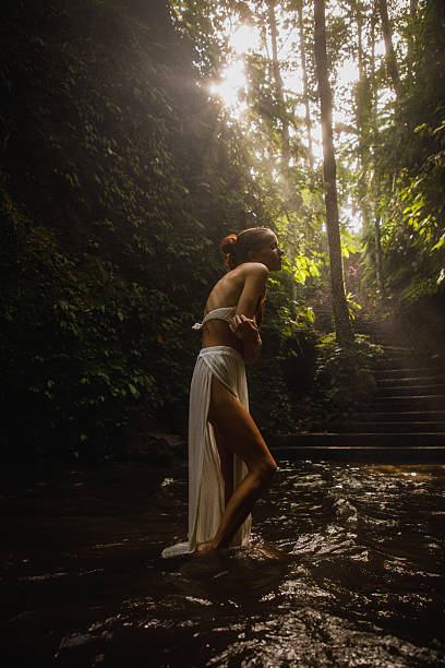 istock Woman exploring serene forest setting with sunlight streaming through vibrant green foliage 2234885137