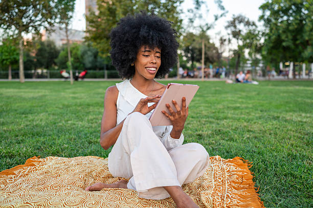 istock Young woman using digital tablet in the park 2234885348