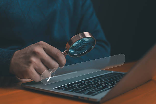 istock Businessman using magnifying glass with laptop and search bar, representing SEO, search engine optimization, online research, business analysis, and digital marketing strategy. 2234886625